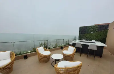 a balcony with chairs and a table on a building at Lovely Aparment OceanView Barranco1809 in Lima