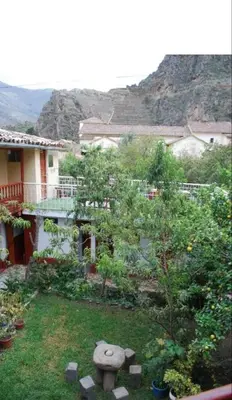 a garden with a birdbath in the yard of a house at Hospedaje La Ñusta in Ollantaytambo