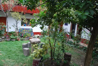 a garden with a small tree and a building at Hospedaje La Ñusta in Ollantaytambo