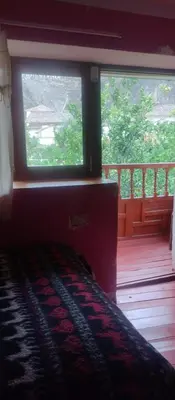 a bedroom with a window and a bed on a porch at Hospedaje La Ñusta in Ollantaytambo