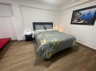 a bedroom with a bed and a painting on the wall at (26) Departamento cómodo y tranquilo en Miraflores in Lima