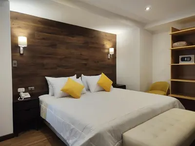 a bedroom with a large white bed with yellow pillows at LA TERRAZA INN in Huancavelica
