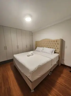 a bedroom with a large bed with white sheets at R&M Apartament in Lima