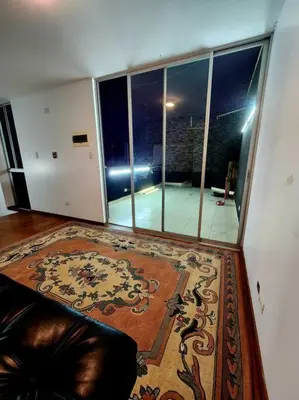 a living room with a couch and a large window at R&M Apartament in Lima