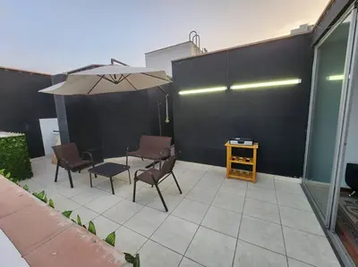 a patio with a table and chairs and an umbrella at R&M Apartament in Lima