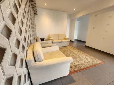 a living room with two white chairs and a wall at R&M Apartament in Lima