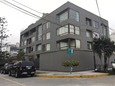 a gray building with cars parked in front of it at Amplio, cómodo y moderno apartamento cerca al Mall in Lima
