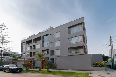 an apartment building with a car parked in front of it at Amplio, cómodo y moderno apartamento cerca al Mall in Lima