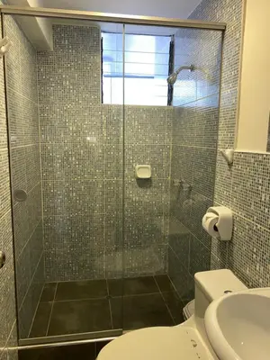 a bathroom with a glass shower with a toilet at Adriano's Deluxe Apartments 1 in Cusco