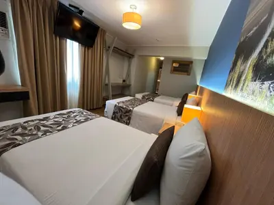 a hotel room with two beds and a tv at Hotel El Tambo 2 in Lima