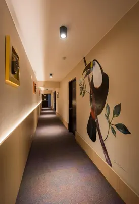a hallway with a painting of a hat on the wall at Hotel El Tambo 2 in Lima