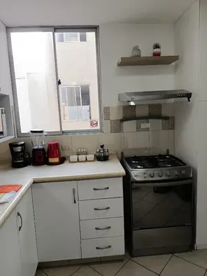 a kitchen with a stove and a counter top at Runawasi Apartments - Amaru 3BDR in Lima