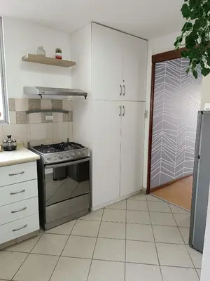 a kitchen with white cabinets and a stove top oven at Runawasi Apartments - Amaru 3BDR in Lima
