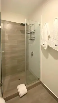 a bathroom with a glass shower stall with towels at The Classic by Wynwood House in Lima