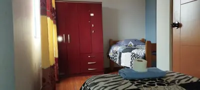 a bedroom with two beds and a red cabinet at depacentrohuancayo in Huancayo