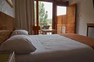 a bedroom with a large bed and a large window at El Molino Hotel y Restaurant in Lunahuaná