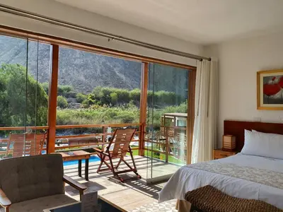 a bedroom with a bed and a balcony with a view at El Molino Hotel y Restaurant in Lunahuaná