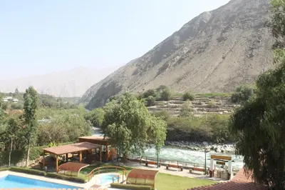 a resort with a swimming pool and a mountain at El Molino Hotel y Restaurant in Lunahuaná