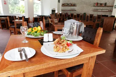 a wooden table with plates of food on it at Lunahuana River Resort in Lunahuaná