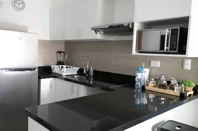 a kitchen with a black counter top and a microwave at Barranco Best Location - Apartment wAC in Lima