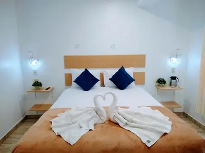 two swans towels sitting on top of a bed at Emmanuel inn Machupicchu in Machu Picchu