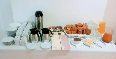 a table with a bunch of breakfast foods and drinks at Emmanuel inn Machupicchu in Machu Picchu