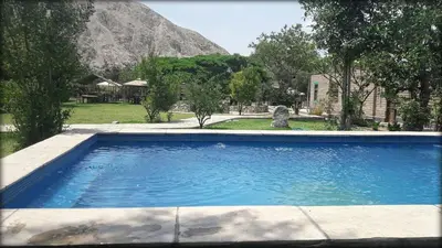 a swimming pool with a mountain in the background at Refugio de Santiago Ecolodge in Lunahuaná