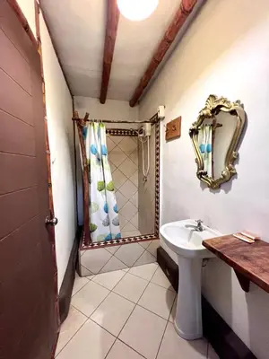 a bathroom with a sink and a shower with a mirror at Refugio de Santiago Ecolodge in Lunahuaná