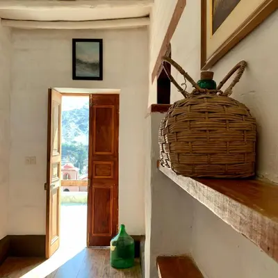 a wicker basket sitting on a wall next to a door at Refugio de Santiago Ecolodge in Lunahuaná