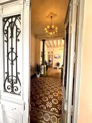 a hallway with a door to a building with a chandelier at Ancestral Hostel Barranco in Lima