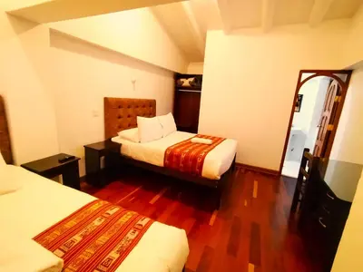 a hotel room with two beds and a mirror at Paqarina San Blas in Cusco