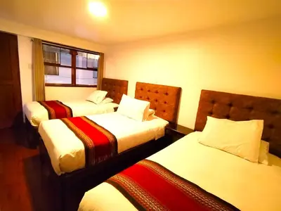 a hotel room with two beds and a window at Paqarina San Blas in Cusco