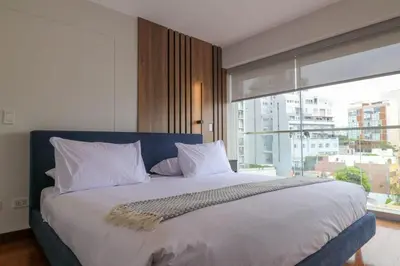 a bedroom with a large bed with a large window at Mimosas 145 by Wynwood House in Lima