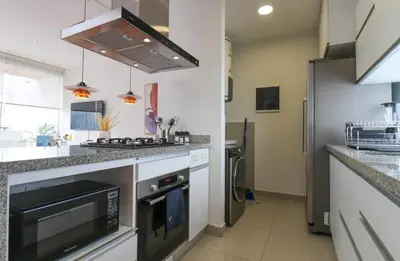 a kitchen with a sink and a stove top oven at Mimosas 145 by Wynwood House in Lima