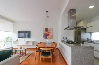 a kitchen and living room with a wooden table and a dining room at Mimosas 145 by Wynwood House in Lima
