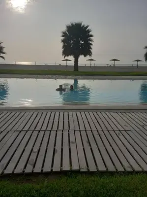 a pool of water with two people in it at The Pacific Cottage in Chincha Baja