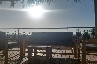 two benches and a table on a deck at The Pacific Cottage in Chincha Baja