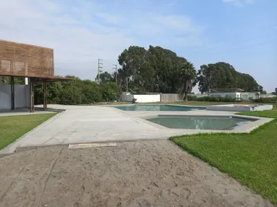 a swimming pool in the middle of a yard at The Pacific Cottage in Chincha Baja
