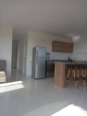 a kitchen with a refrigerator and a table in it at The Pacific Cottage in Chincha Baja