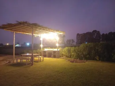 a picnic table under a canopy in a field at night at The Pacific Cottage in Chincha Baja
