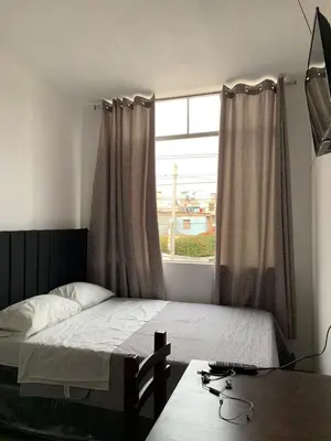 a bedroom with a bed with a window and a desk at RESIDENCIAL SALAMANCA in Lima
