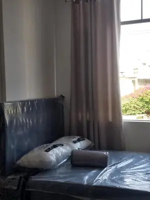 a bed with a leather head board and a window at RESIDENCIAL SALAMANCA in Lima