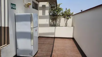 a stainless steel refrigerator sitting outside of a building at Hermoso departamento amoblado con piscina, area parrillas in Lima