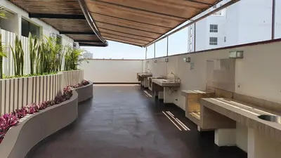 a public restroom with sinks and plants at Hermoso departamento amoblado con piscina, area parrillas in Lima