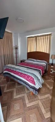a bed in a room with a wooden floor at R. A. C. S. in Paracas