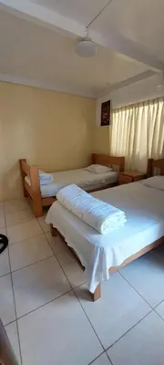 a room with three beds in a room at R. A. C. S. in Paracas