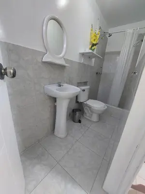 a bathroom with a sink and a toilet and a mirror at R. A. C. S. in Paracas
