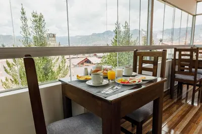 a breakfast table in a balcony with a view at Dreams Boutique Hotel Cusco in Cusco