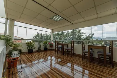an empty room with tables and chairs and windows at Dreams Boutique Hotel Cusco in Cusco