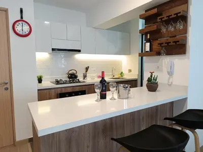 a kitchen with white cabinets and a counter with wine glasses at Runawasi Apartments - Killary Miraflores 2BDR in Lima